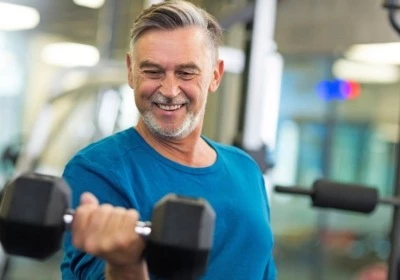 Un vieil homme heureux dans une salle de sport.