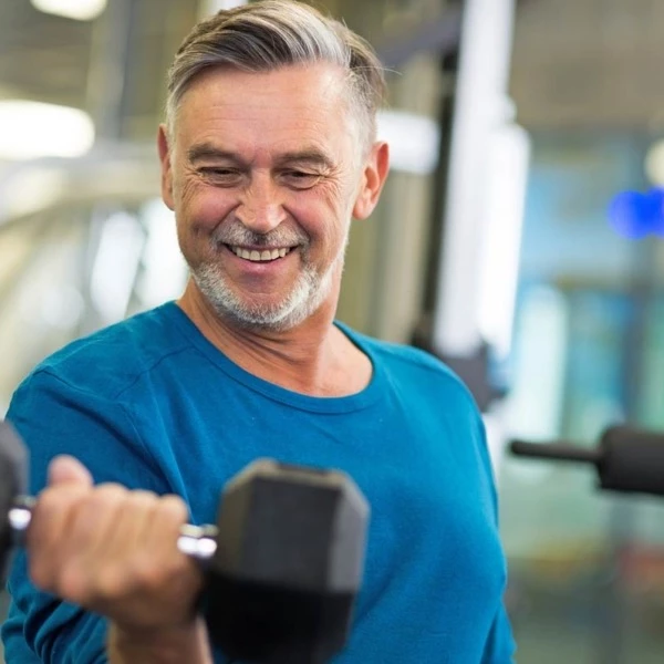 Un vieil homme heureux dans une salle de sport.