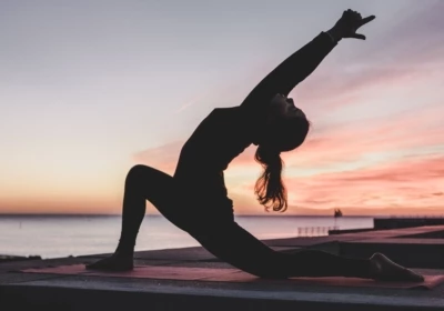 une fille pratiquant le yoga au coucher du soleil